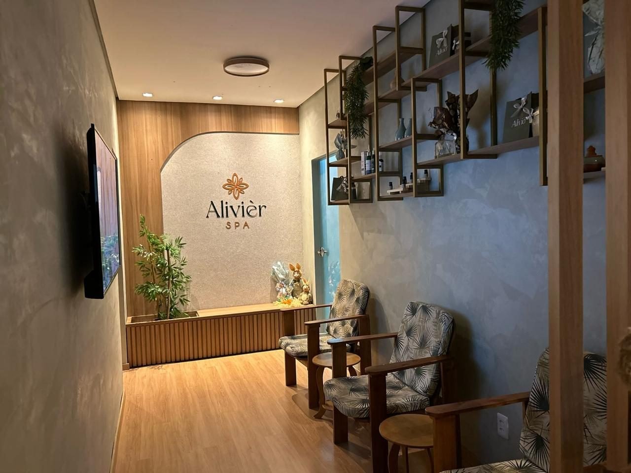 Recepção do Alivièr Spa, com letreiro da marca, parede verde viva e poltronas de espera